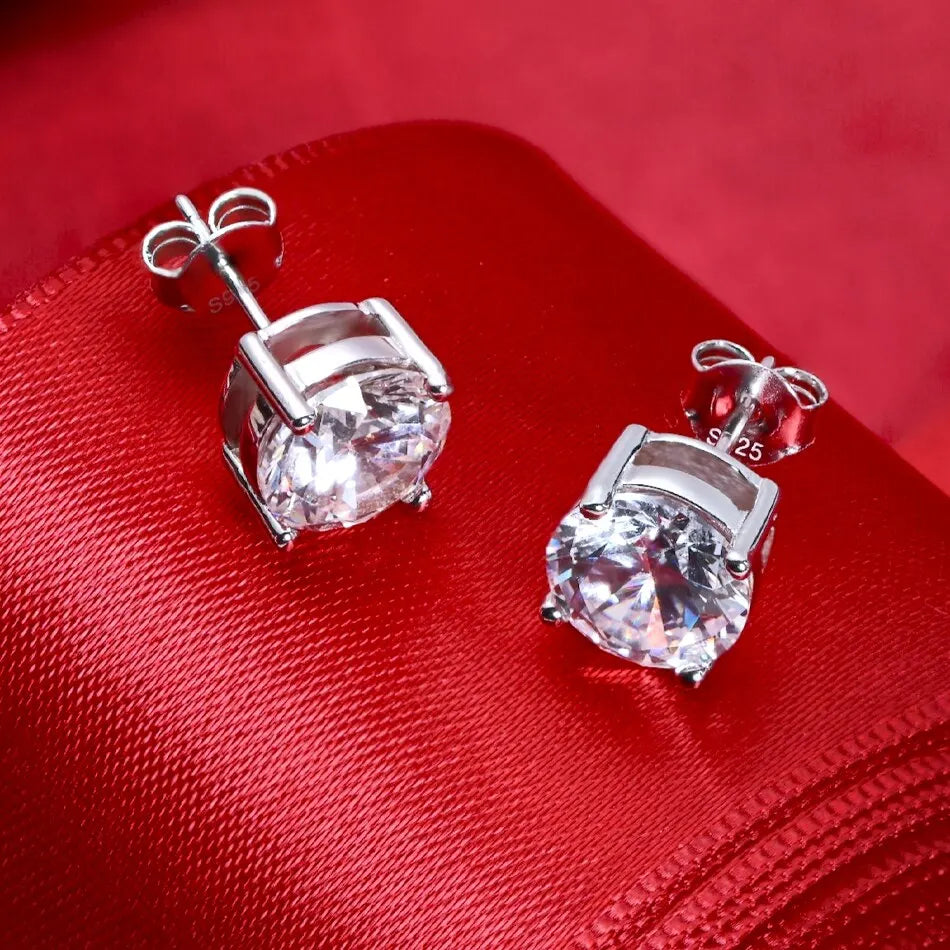 Moissanite stud earrings on red fabric